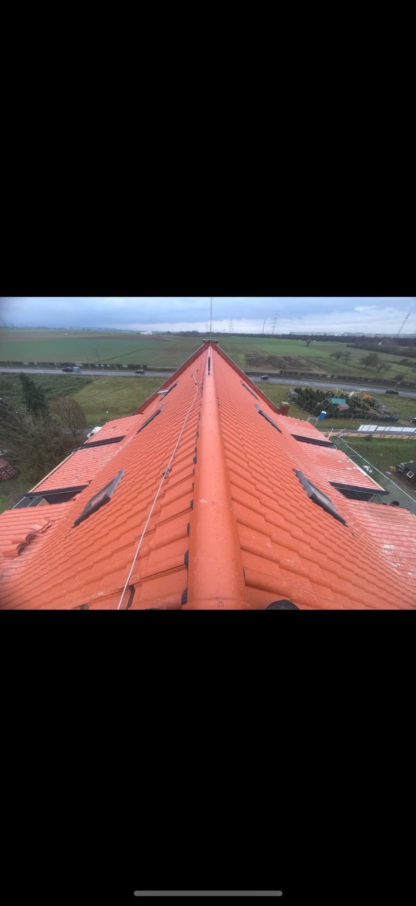 Lange Firstperspektive einer neuen terrakottafarbenen Ziegeldeckung